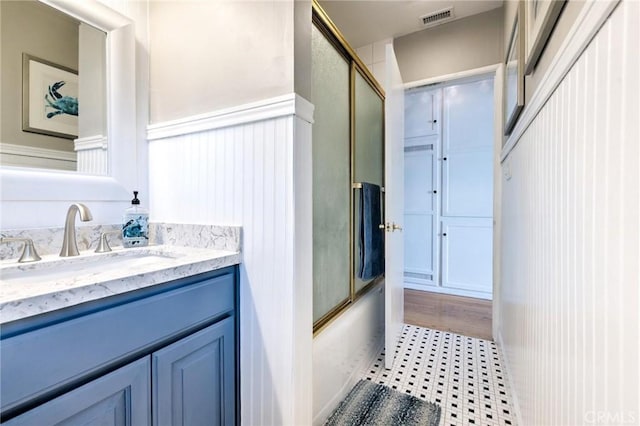 bathroom featuring combined bath / shower with glass door and vanity