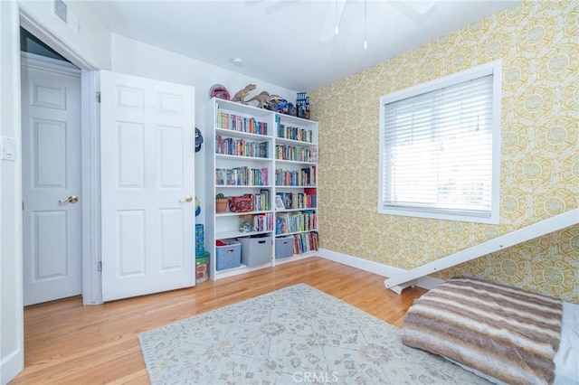 living area with hardwood / wood-style floors and ceiling fan