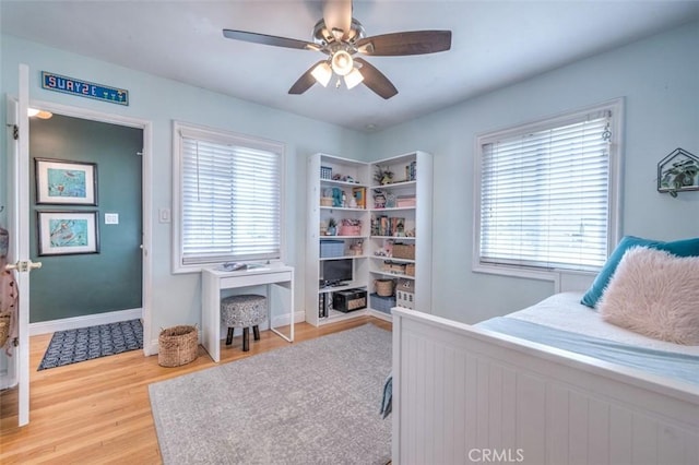 bedroom with wood-type flooring, multiple windows, and ceiling fan