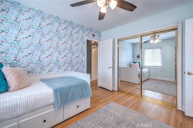 bedroom with ceiling fan, a closet, and hardwood / wood-style flooring