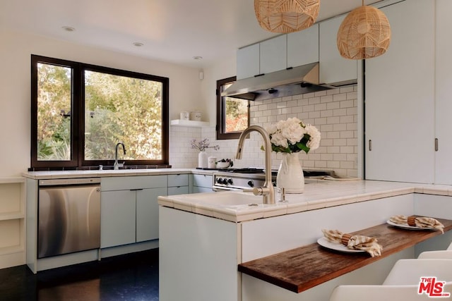 kitchen with tasteful backsplash, white cabinets, sink, pendant lighting, and dishwasher