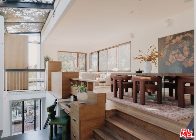 dining space with wood-type flooring and a towering ceiling