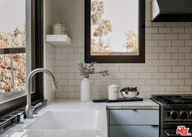 bathroom featuring plenty of natural light, sink, and backsplash