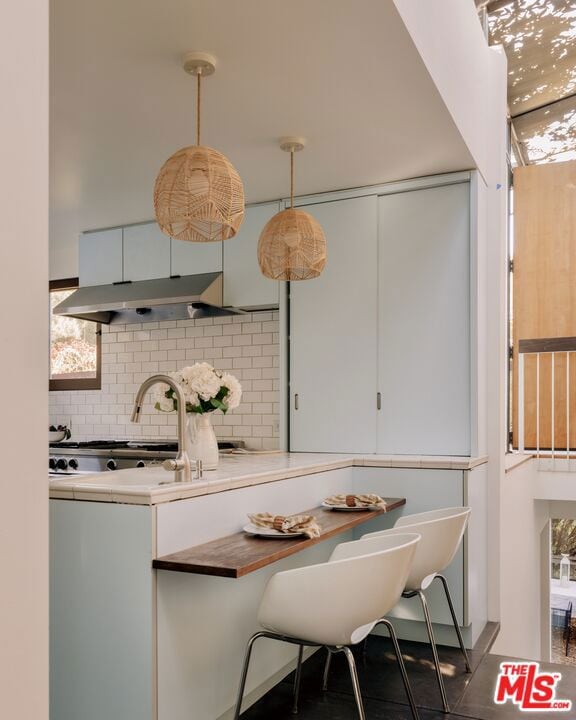 kitchen featuring white cabinetry, hanging light fixtures, and tasteful backsplash