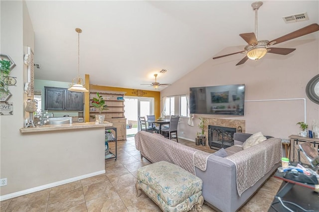 tiled living room with ceiling fan and high vaulted ceiling