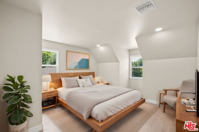 bedroom featuring lofted ceiling and light hardwood / wood-style flooring