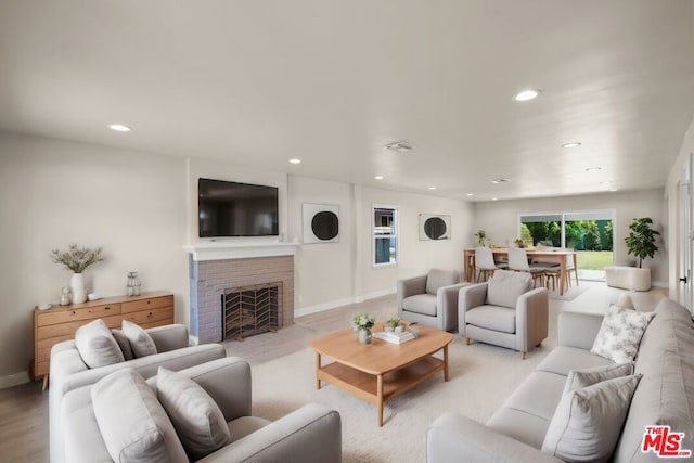 living room featuring light hardwood / wood-style floors and a brick fireplace