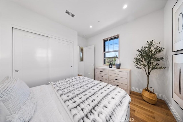 bedroom with a closet and hardwood / wood-style floors