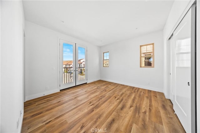 unfurnished room with light hardwood / wood-style floors and french doors