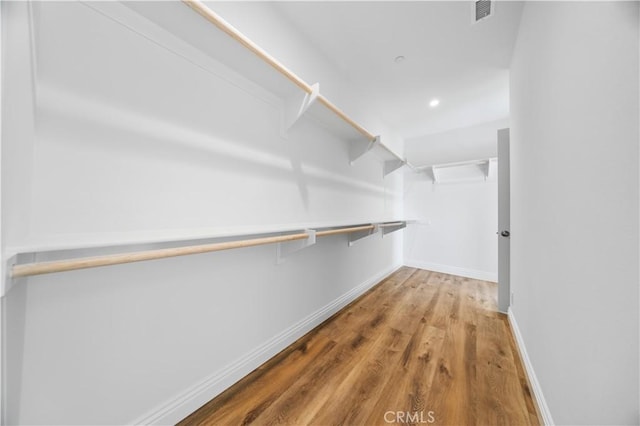 walk in closet with hardwood / wood-style floors