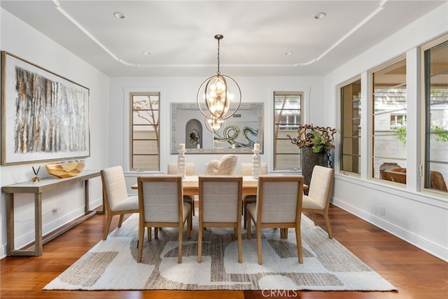 dining area with hardwood / wood-style flooring and a chandelier