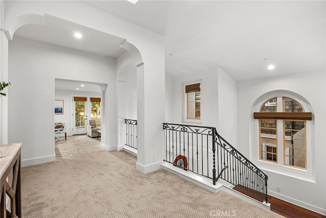 hallway with french doors and light colored carpet