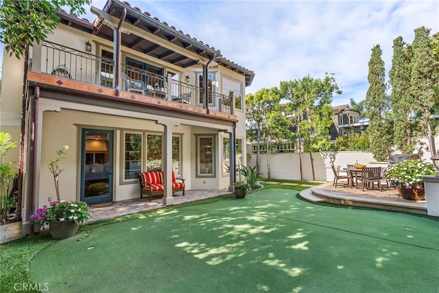 back of property featuring a balcony and a patio