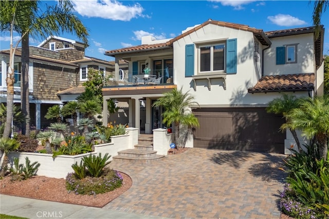 mediterranean / spanish-style house featuring a balcony and a garage