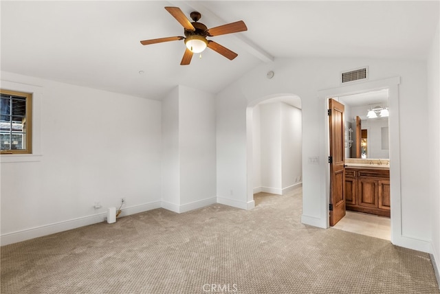 spare room featuring ceiling fan, lofted ceiling with beams, and light colored carpet