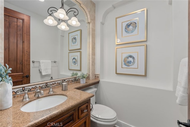 bathroom with vanity, toilet, and a chandelier