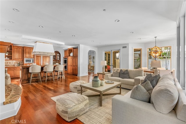 living room featuring dark wood-type flooring and an inviting chandelier