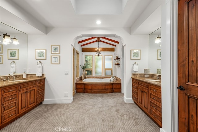 bathroom with a bathing tub, vanity, and a chandelier