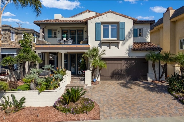 mediterranean / spanish house featuring a balcony and a garage