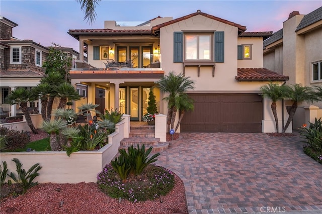 mediterranean / spanish-style house with a balcony and a garage