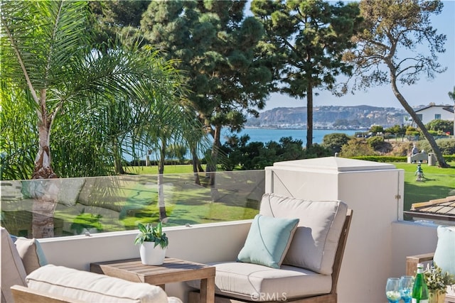 exterior space featuring a balcony and a water and mountain view