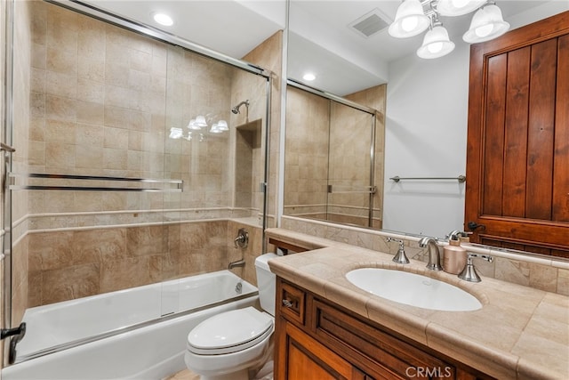 full bathroom featuring vanity, toilet, and bath / shower combo with glass door