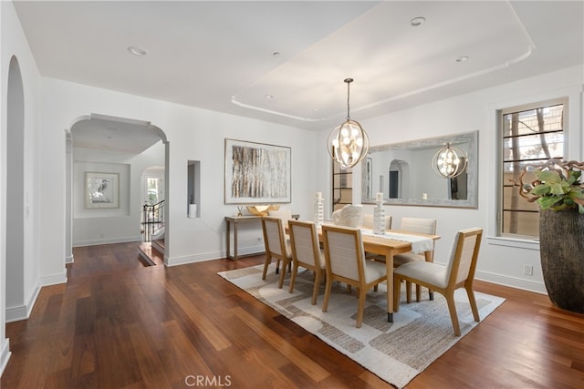 dining space featuring dark hardwood / wood-style floors and an inviting chandelier