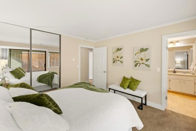 bedroom featuring ensuite bathroom, light colored carpet, a closet, and ornamental molding