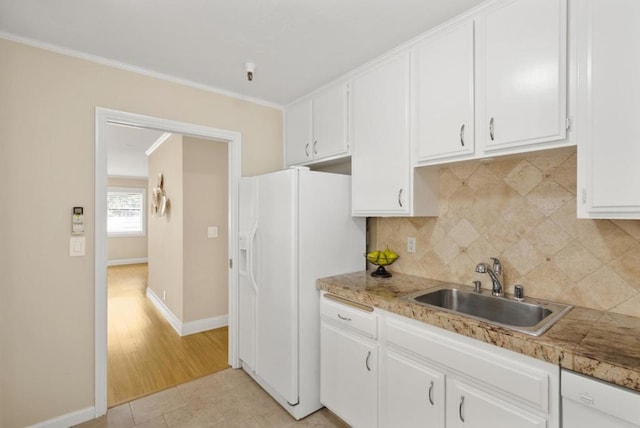 kitchen featuring light tile patterned floors, sink, white appliances, and white cabinets