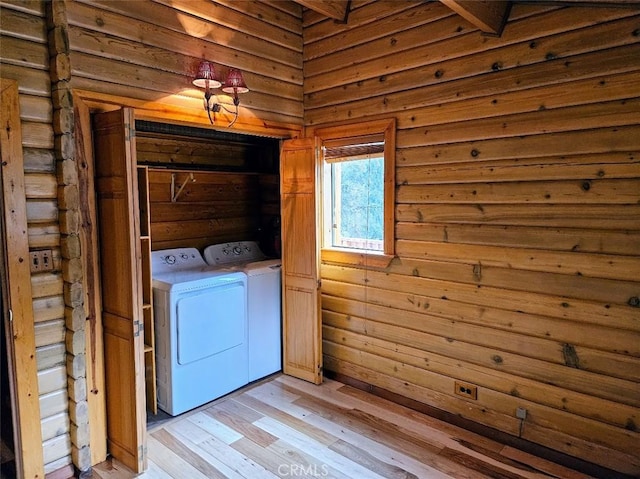 clothes washing area with separate washer and dryer and light wood-type flooring