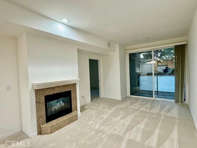 unfurnished living room with carpet floors and a premium fireplace