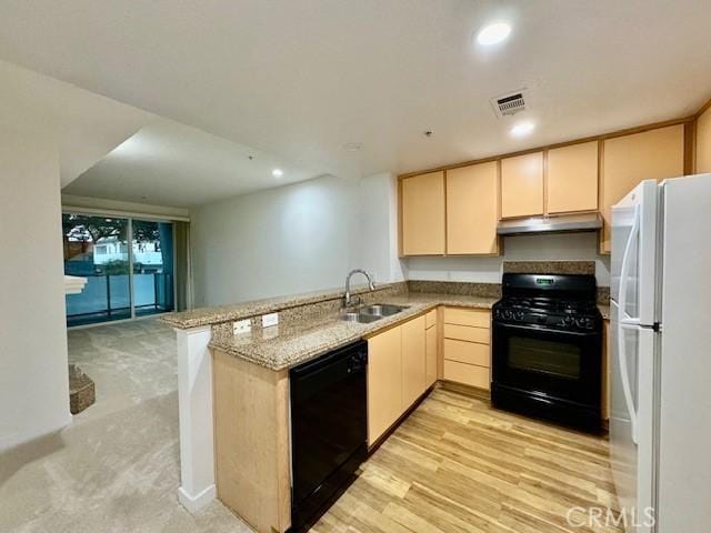 kitchen with kitchen peninsula, light stone counters, sink, black appliances, and light brown cabinets