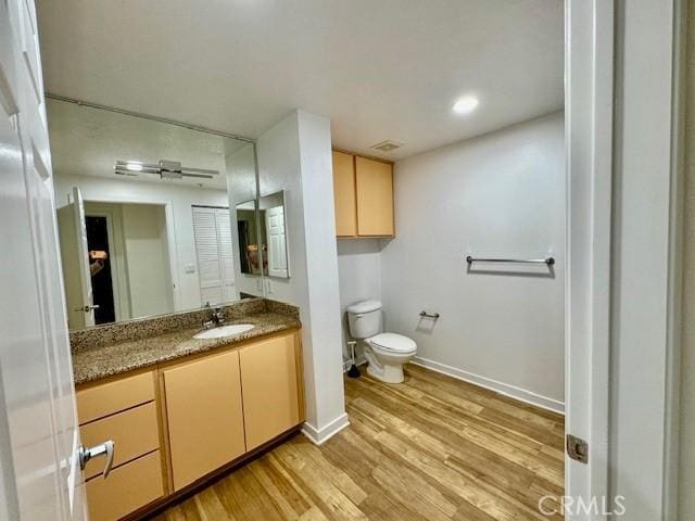 bathroom featuring hardwood / wood-style floors, vanity, and toilet