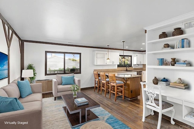 living room with a wealth of natural light, ornamental molding, and dark wood-style flooring