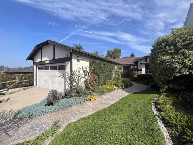 view of front of home featuring a front yard, driveway, an attached garage, and stucco siding