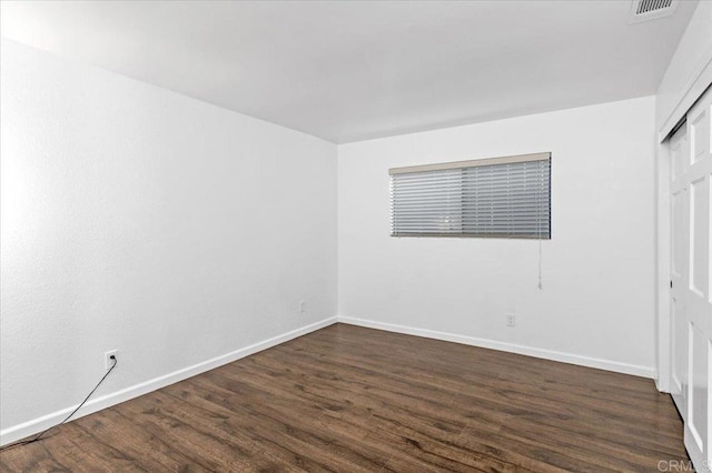 unfurnished bedroom featuring dark wood finished floors and baseboards