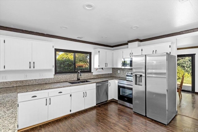 kitchen featuring appliances with stainless steel finishes, white cabinetry, and a sink