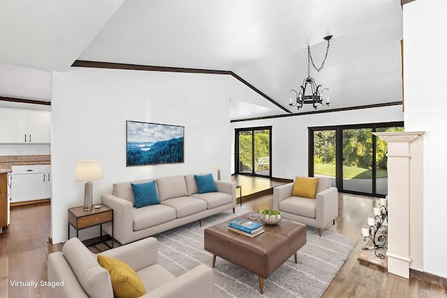 living area with light wood-type flooring, vaulted ceiling, and a notable chandelier