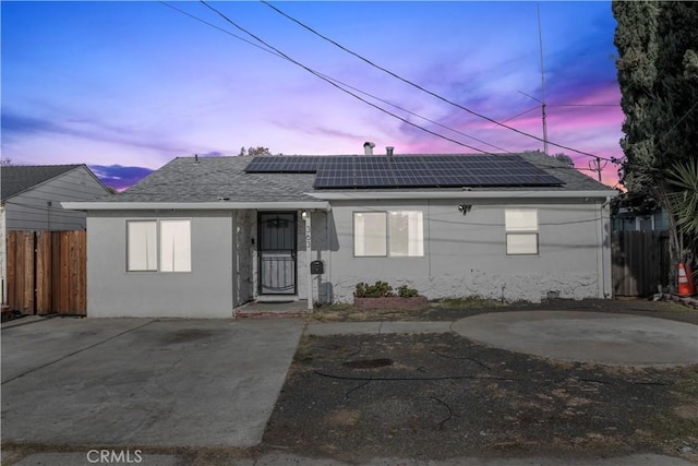 view of front of home with solar panels and a patio area