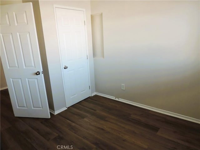 unfurnished bedroom with dark hardwood / wood-style flooring