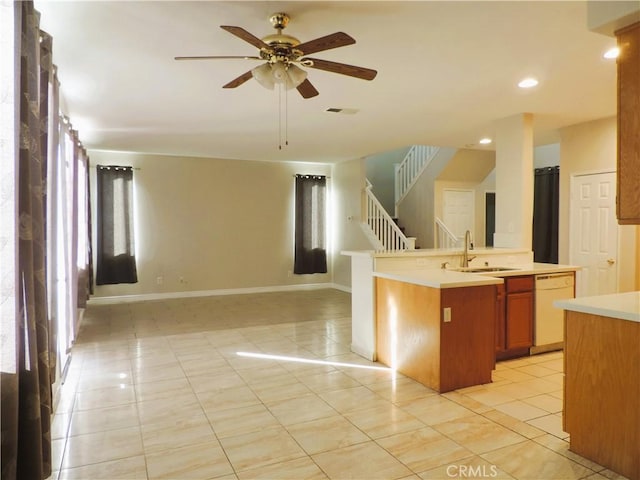 kitchen with dishwasher, a center island with sink, sink, ceiling fan, and light tile patterned floors