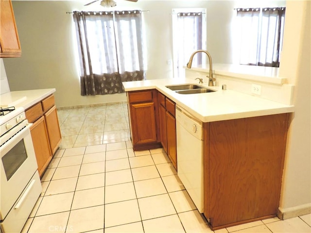 kitchen featuring ceiling fan, sink, an island with sink, white appliances, and light tile patterned flooring