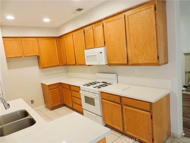 kitchen featuring sink, light tile patterned floors, and white appliances