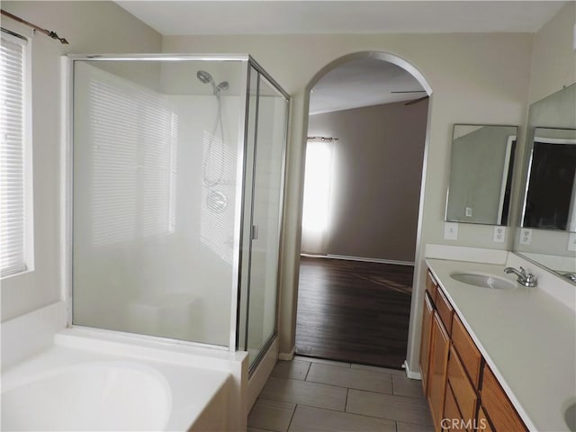 bathroom featuring plus walk in shower, vanity, and tile patterned flooring