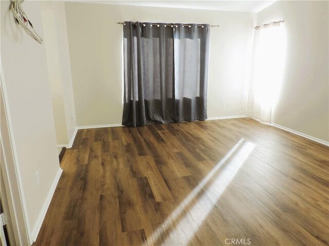 empty room with dark wood-type flooring