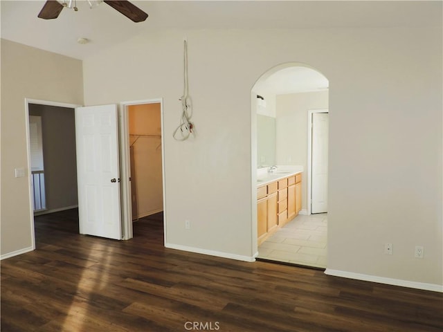 spare room featuring ceiling fan, sink, and dark wood-type flooring