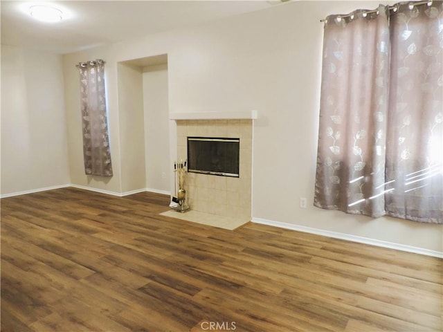 unfurnished living room featuring a fireplace and hardwood / wood-style flooring