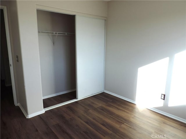 interior space with dark hardwood / wood-style floors and a closet