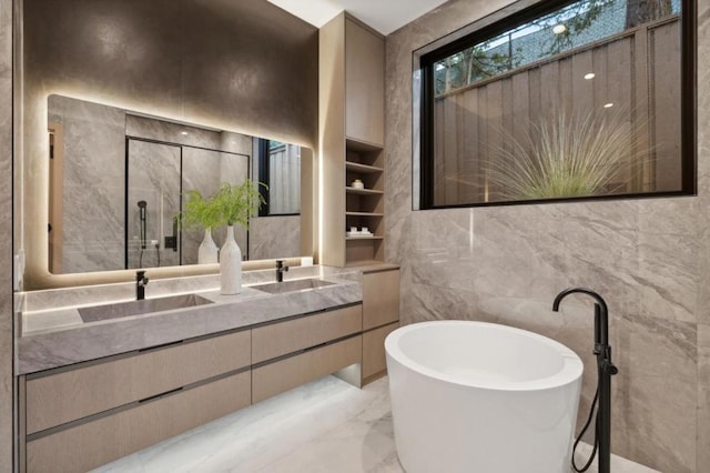 bathroom featuring a bathing tub, vanity, and tile walls