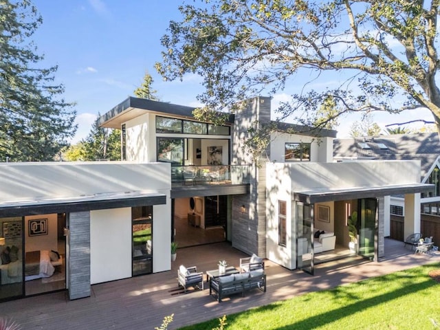 rear view of house with outdoor lounge area, a balcony, and a deck